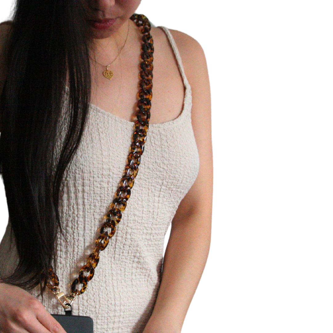 Girl with long dark hair wearing a brown coloured crossbody phone strap.